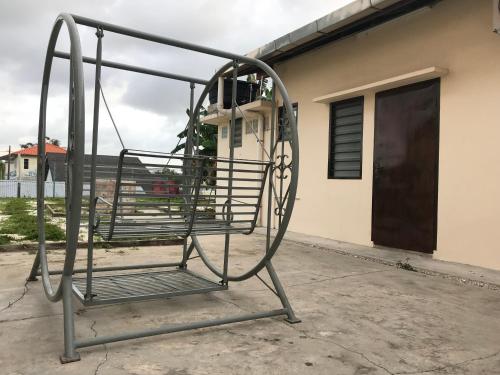 a metal swing in front of a building at SingVillage Holiday House in Mersing