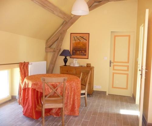 ein Esszimmer mit einem Tisch und einem Schreibtisch in der Unterkunft La maison des fleurs in Saint-Senoch