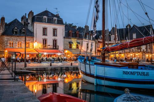 una barca ormeggiata in un porto turistico di una città di notte di Kyriad Auray ad Auray