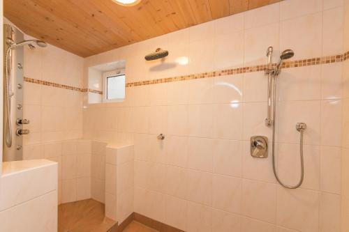 biała łazienka z prysznicem i wanną w obiekcie Ferienwohnung Simair w mieście St. Ulrich am Pillersee