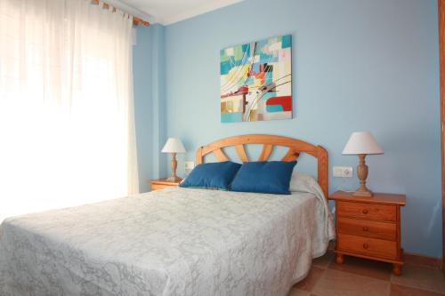 una camera con letto e parete blu di OLIVA HOLIDAYS 1 a Oliva