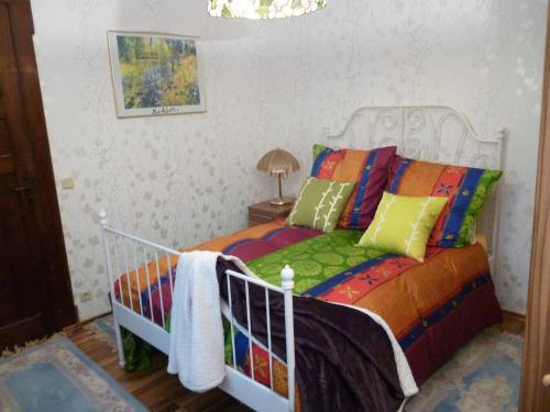 a bedroom with a bed with colorful pillows at Villa Charlotte in Bad Liebenstein