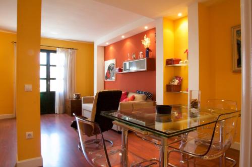 塞维利亚Apartamento San Benito C的带玻璃桌椅的客厅