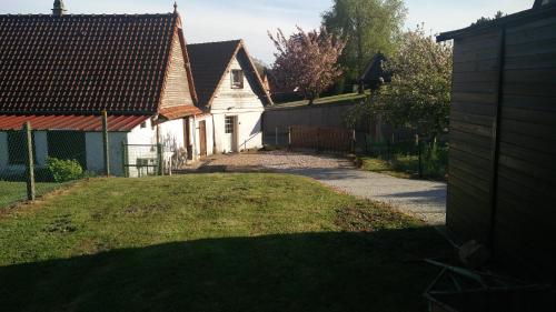 einen Hof mit einem Haus und einem Zaun in der Unterkunft Gîte La Cavée in Le Bourg-Dun
