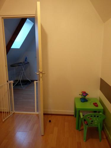 a room with a green table and a mirror at Gîte La Cavée in Le Bourg-Dun