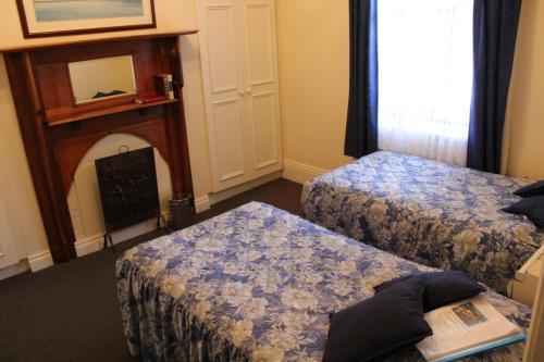 a bedroom with a bed and a desk with a laptop at Benambra Queenscliff in Queenscliff