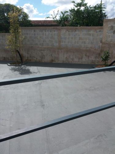 a tennis court in front of a brick wall at Rez Home Catas Altas in Catas Altas