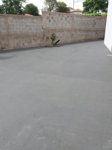 a concrete parking lot next to a brick wall at Rez Home Catas Altas in Catas Altas