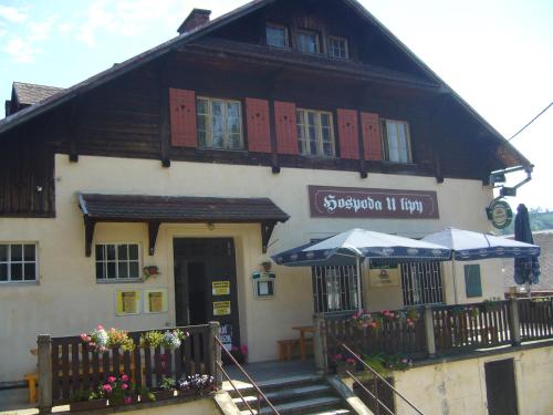 a building with two umbrellas in front of it at Hospoda U Lípy in Ostrov