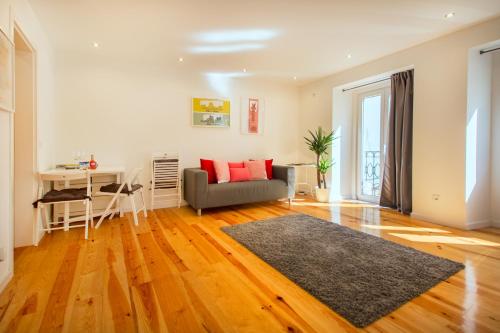 ein Wohnzimmer mit einem Sofa und einem Schreibtisch in der Unterkunft Bica Historical Tram Apartment in Lissabon