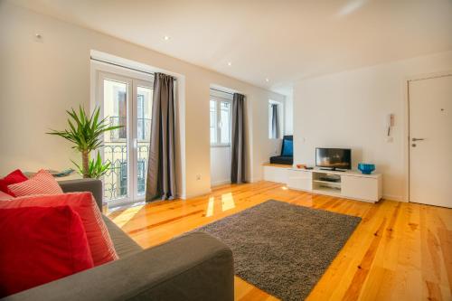 ein Wohnzimmer mit einem Sofa und einem TV in der Unterkunft Bica Historical Tram Apartment in Lissabon