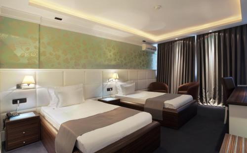 a hotel room with two beds and a television at Garni Hotel Crystal in Kraljevo