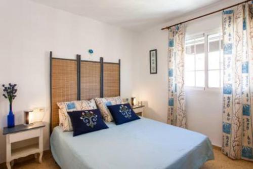 バレンシアにあるApartamento Malvarosaのベッドルーム1室(青い枕のベッド1台、窓付)