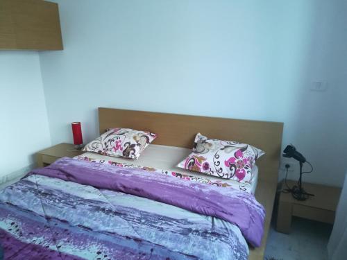 a bedroom with a bed with purple sheets and pillows at Loft Aziz in Tunis