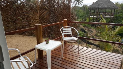 a balcony with a chair and a table and a gazebo at Pousada Entre as Águas in Imbassai
