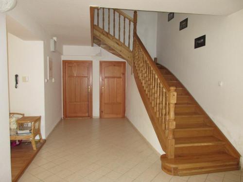 a hallway with a wooden staircase in a house at Villa Cechy in Hnilčík