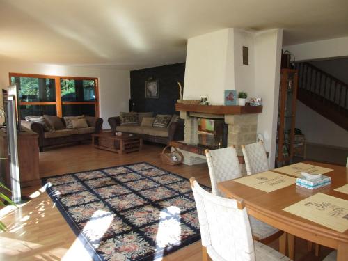 a living room with a table and a fireplace at Villa Cechy in Hnilčík