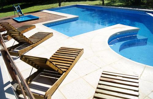 a group of chairs sitting next to a swimming pool at Cabañas Aguaflorida in Gualeguay