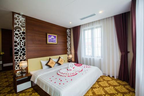 a hotel room with a bed with a cake on it at Grand Hotel in Hòa Bình