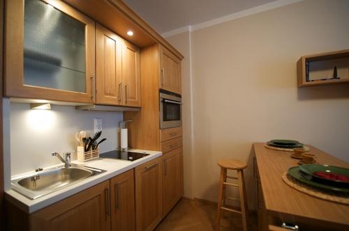 a kitchen with wooden cabinets and a sink and a counter at Apartmany Alectis in Pec pod Sněžkou