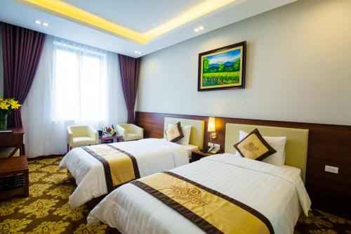 a hotel room with two beds and a window at Grand Hotel in Hòa Bình