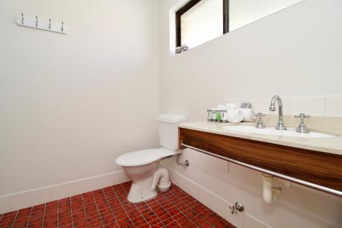 a bathroom with a toilet and a sink at Hotel Clipper in Rockingham