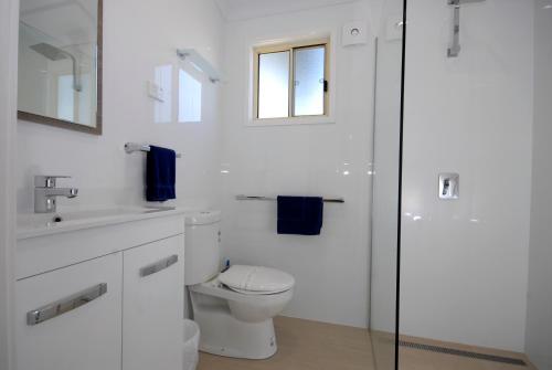 Barrack Point的住宿－百瑞可度假村，白色的浴室设有卫生间和水槽。