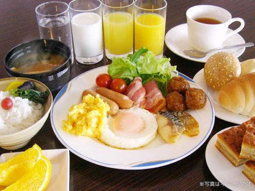 a table topped with plates of breakfast foods and drinks at Hotel Muroran Hills in Muroran