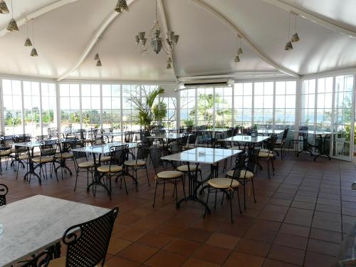 una sala da pranzo con tavoli, sedie e finestre di Hotel Santa María a Palos de la Frontera