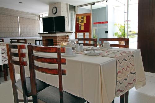a dining room with a table and chairs and a television at Samana Hotel in Arequipa