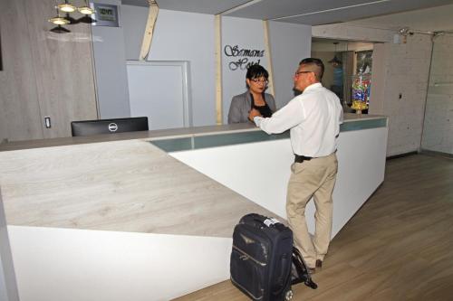 a man standing at a counter with a suitcase at Samana Hotel in Arequipa