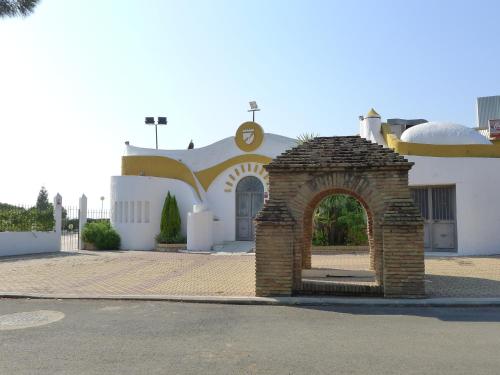 a church with an arch in front of a building at Hotel Santa María in Palos de la Frontera