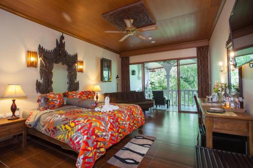 a bedroom with a bed and a living room at Tropica Bungalow Beach Hotel in Patong Beach