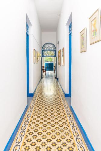 a hallway with blue and white walls and a tile floor at Casa Caribe Colonial in Barranquilla