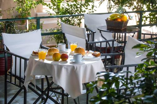 Golden Sun Holiday Apts by Estia في خيرسونيسوس: طاولة مع الفاكهة وعصير البرتقال على الشرفة