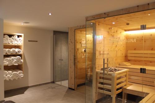 Łazienka z prysznicem i szklanymi drzwiami w obiekcie Pension Michael w Saalbach Hinterglemm