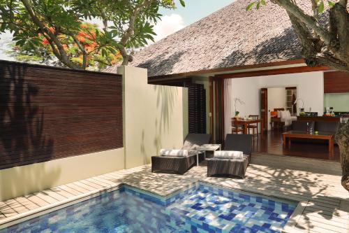 a villa with a swimming pool and a house at Downtown Villas in Seminyak