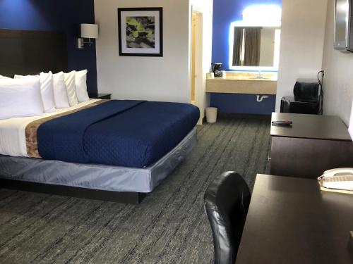 a hotel room with a bed and a sink at Executive Inn and Suites Joaquin in Joaquin