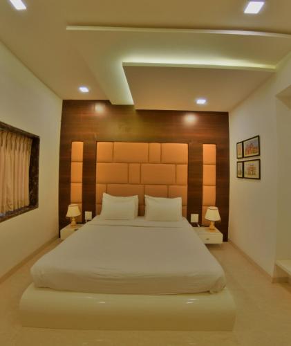 a bedroom with a large bed and two lamps at Hotel Rezo's in Baga