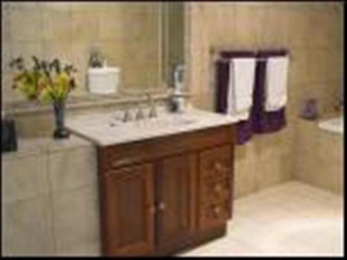 uma casa de banho com um lavatório, um espelho e uma banheira em Highwood Park B&B Guest Lodge em Maleny