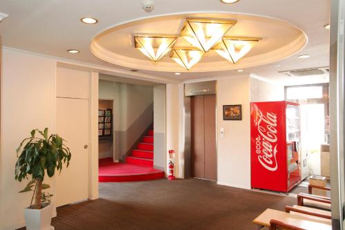 a lobby with a coke sign and a cocacola sign on the ceiling at Hotel Rumieru Hyuga in Hyuga