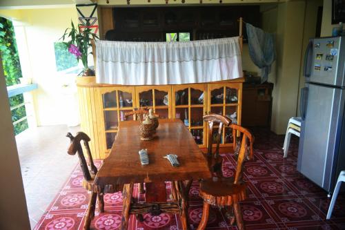 a kitchen with a wooden table with chairs and a refrigerator at Highland Inn and Restaurant in Banaue