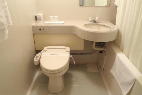 a small bathroom with a toilet and a sink at Hotel Rumieru Hyuga in Hyuga