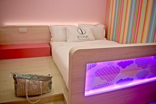a bedroom with a bed with a laptop on it at Iconic Suites & Pods Hotel in Ipoh