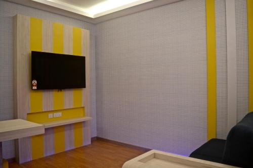 a living room with a flat screen tv on a wall at Iconic Suites & Pods Hotel in Ipoh
