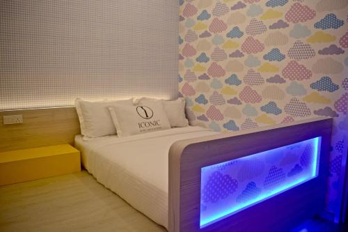 a small bedroom with a bed and a tv at Iconic Suites & Pods Hotel in Ipoh