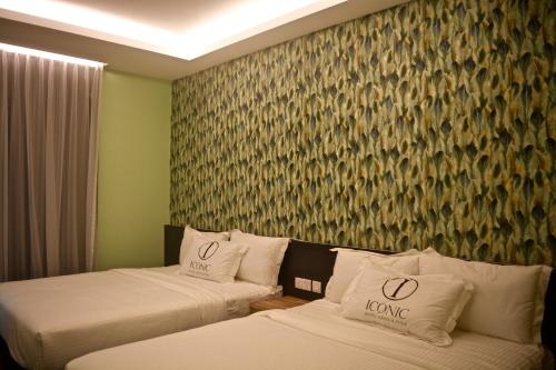 a hotel room with two beds and a wall mural at Iconic Suites & Pods Hotel in Ipoh