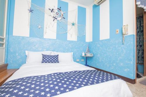 a bedroom with blue and white walls and a bed at CT Theme Suite in Kaohsiung