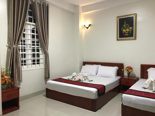 a bedroom with two beds and a window at Truong Ca Hotel in Phan Thiet