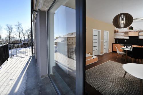 a room with a balcony with a view of the city at APLEND Vila Olívia in Smokovce